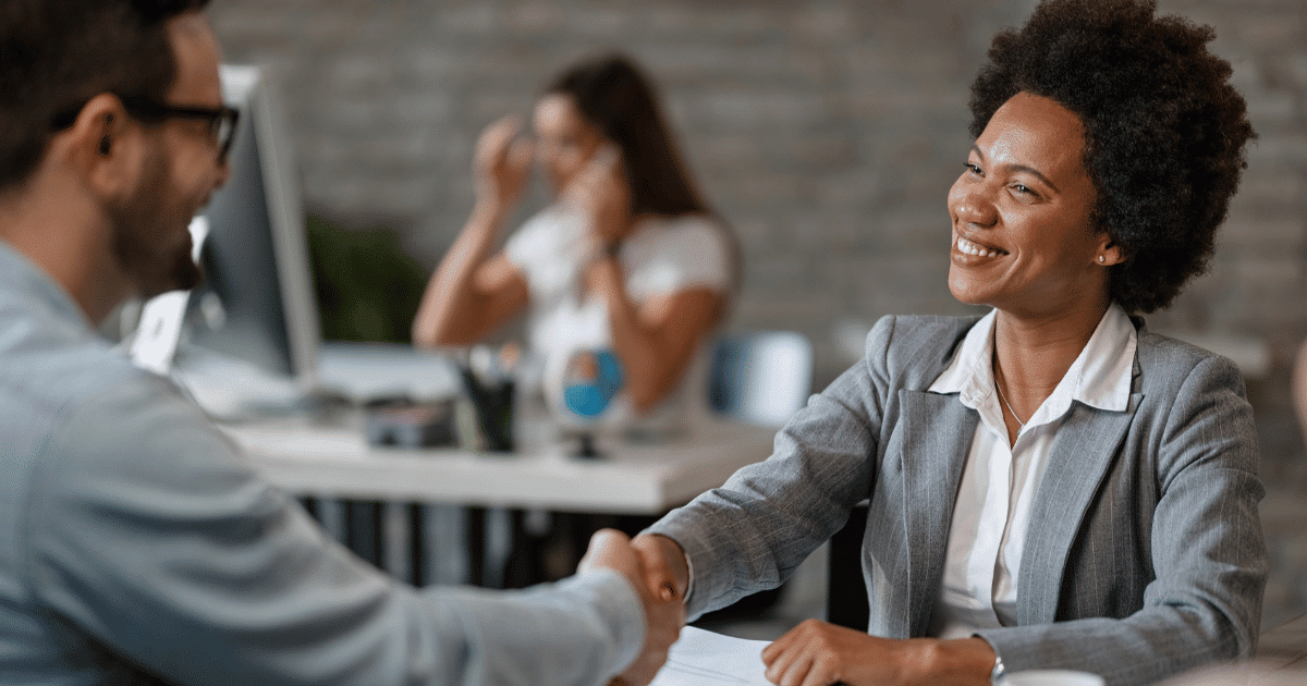 woman shaking hands with a man while sitting at a table