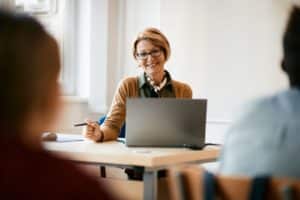 Woman smiling while sitting in front of her laptop