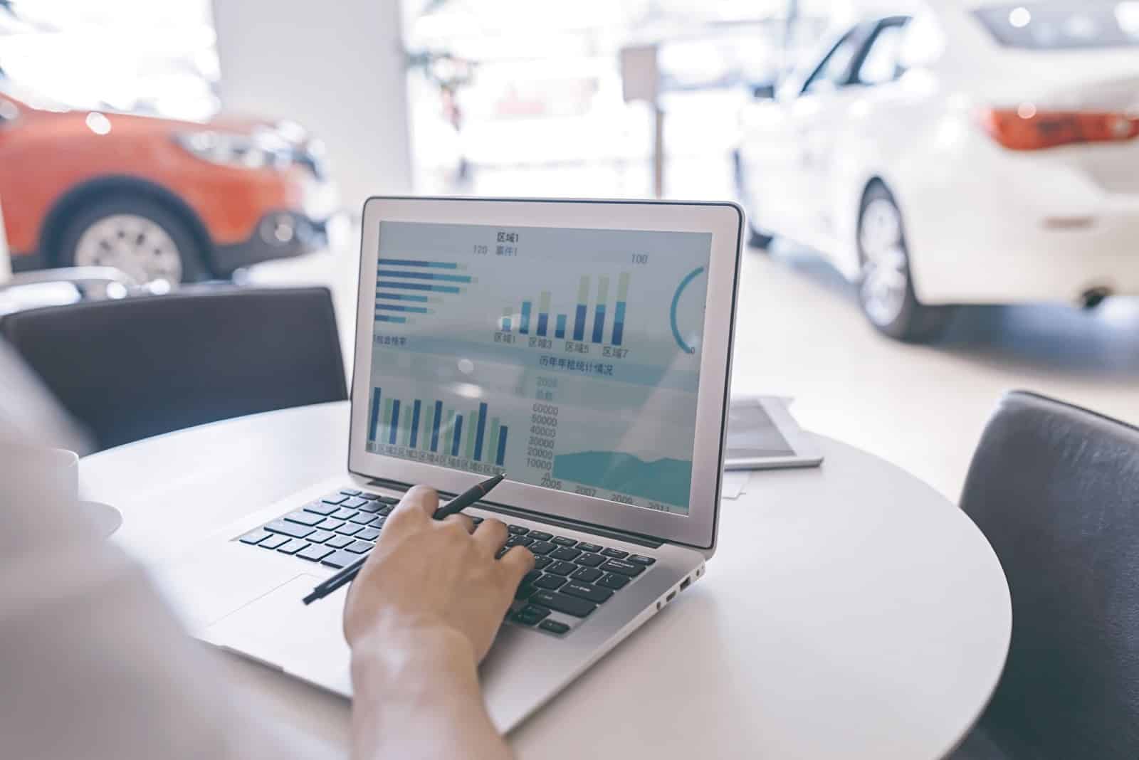 person working in a car dealership on laptop