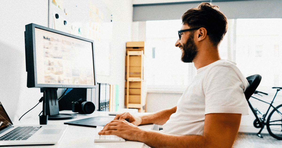 Man sitting at a desk and working on a computer | GUIDEcx