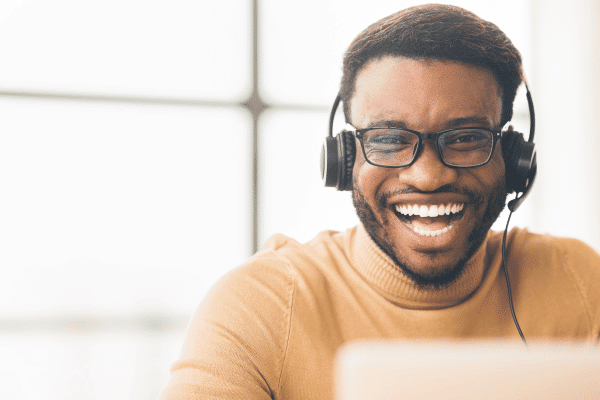 Male sitting at computer and smiling