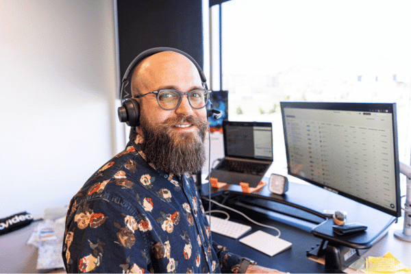 Man with headphones on, sitting at a computer